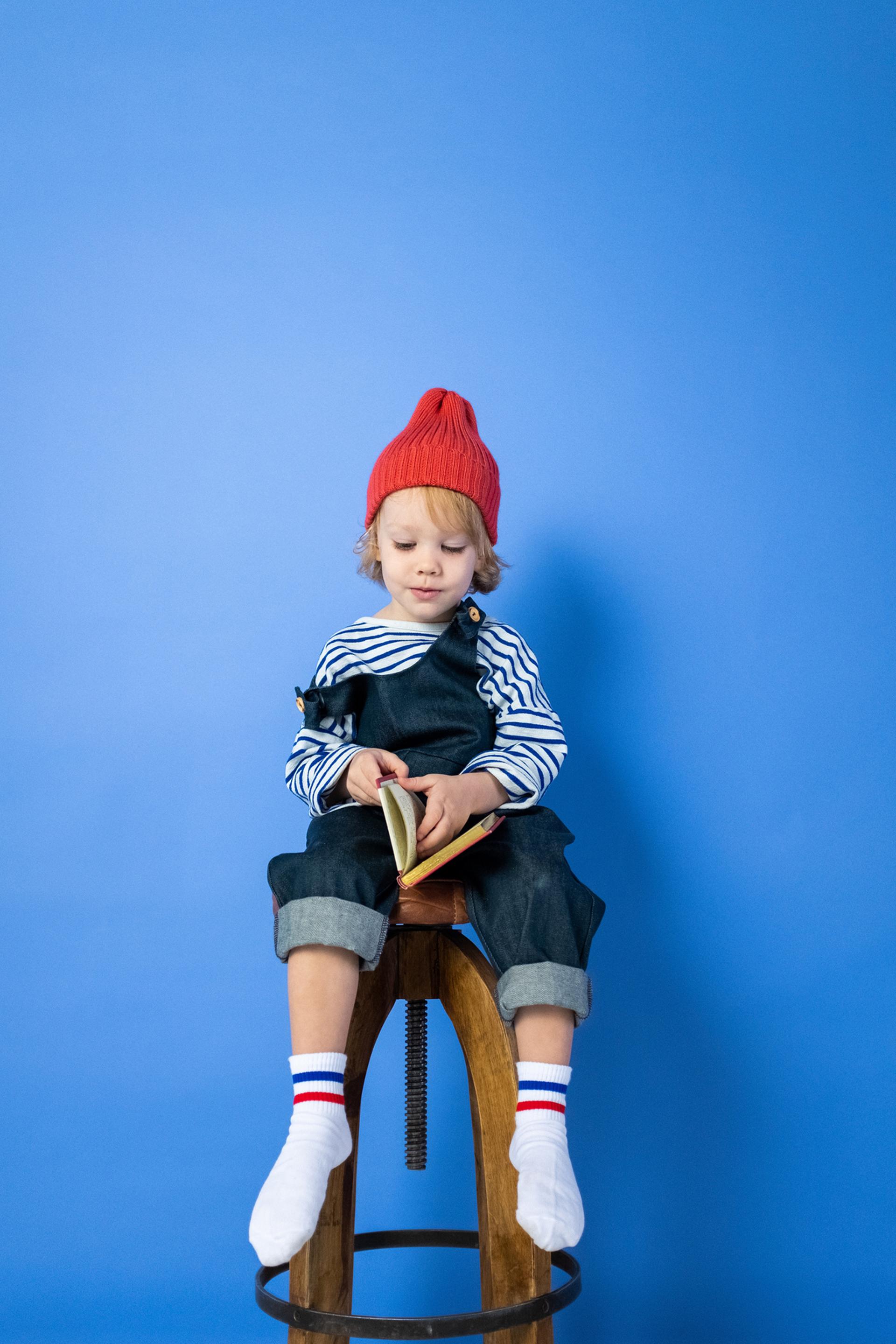 Enfant assis sur un tabouret lisant un livre